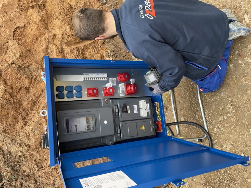Mann bei Schaltkasten im Freien, Elektro Özdemir